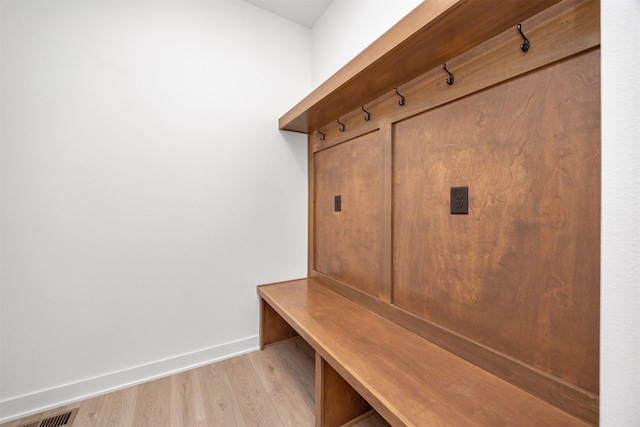 mudroom with light wood-style floors, baseboards, and visible vents