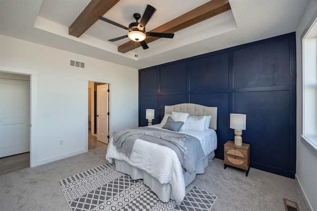 bedroom featuring ceiling fan, a raised ceiling, and light carpet