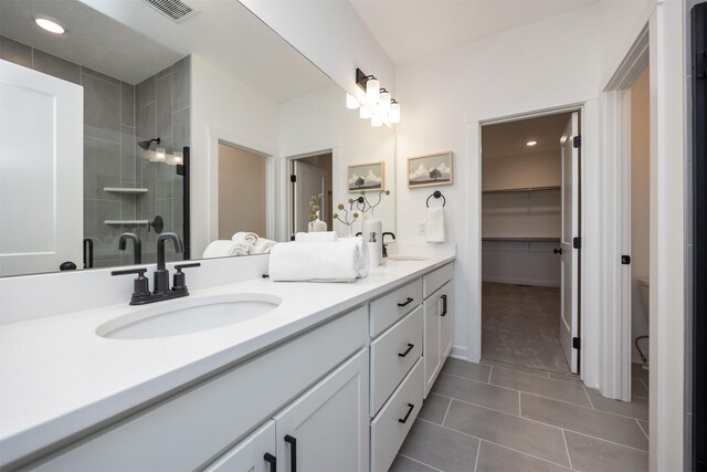 bathroom featuring tile patterned flooring, vanity, toilet, and a shower with shower door