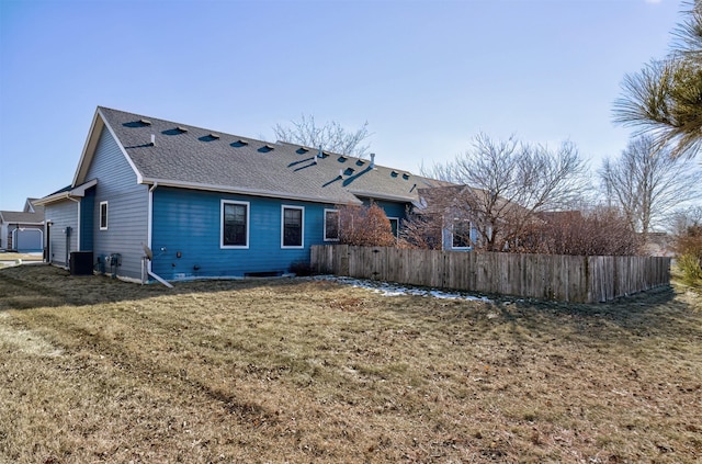 rear view of property with a yard and central air condition unit