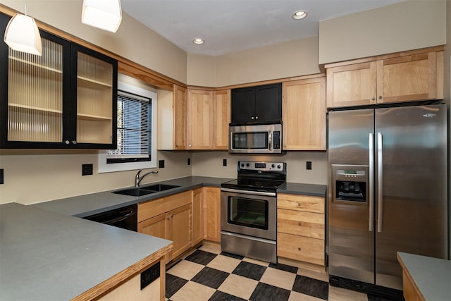 kitchen with appliances with stainless steel finishes, sink, pendant lighting, and light brown cabinetry