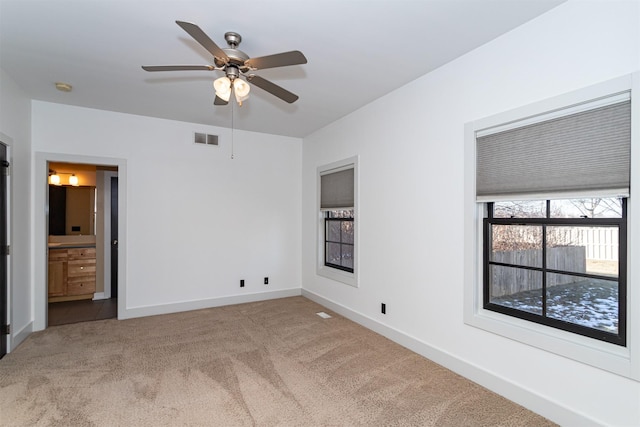 unfurnished bedroom with ceiling fan, connected bathroom, and carpet flooring