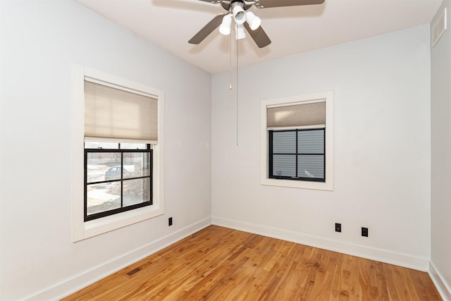 empty room with ceiling fan and light hardwood / wood-style flooring