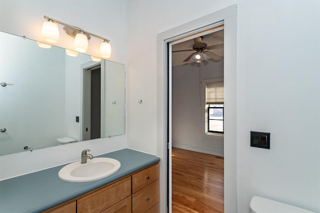 bathroom featuring ceiling fan, vanity, toilet, and wood-type flooring