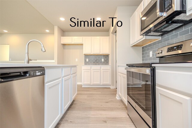 kitchen featuring sink, white cabinetry, stainless steel appliances, tasteful backsplash, and light hardwood / wood-style floors