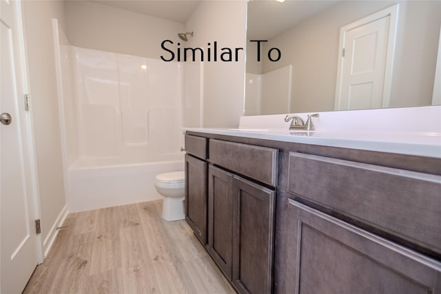 full bathroom with hardwood / wood-style flooring, vanity, shower / washtub combination, and toilet