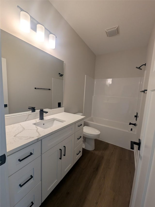 full bathroom featuring vanity, hardwood / wood-style floors, bathtub / shower combination, and toilet