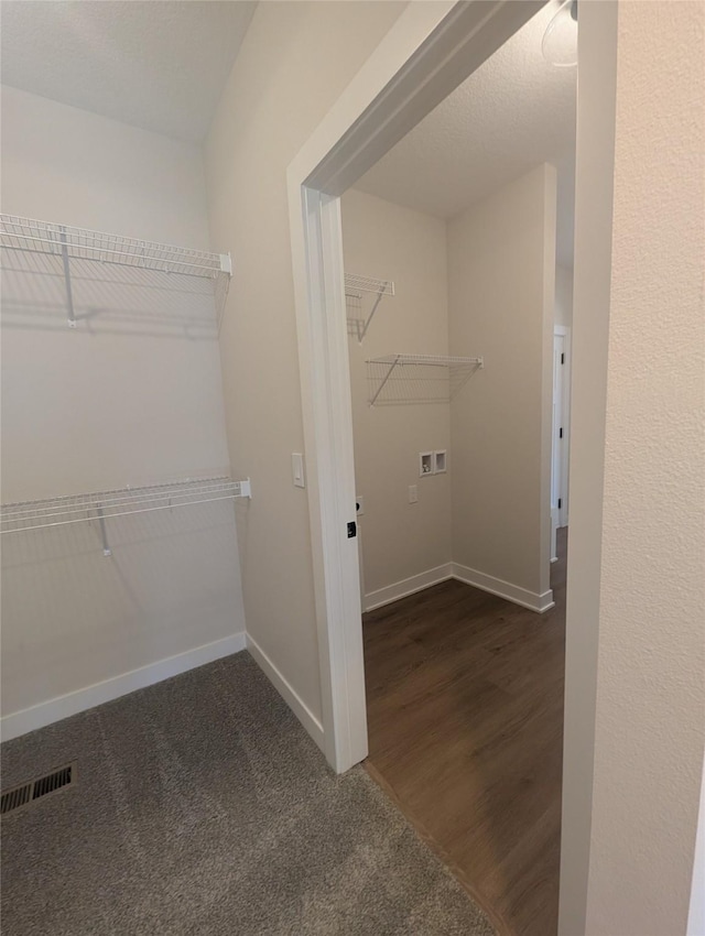 spacious closet featuring dark carpet