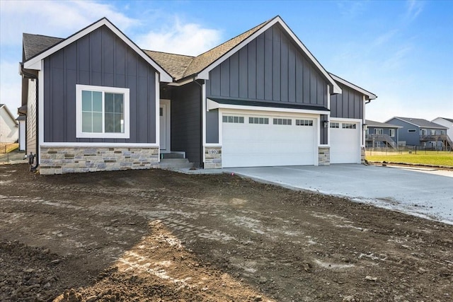 1902 16th Cir SE, Altoona, IA 50009 - view of front of home featuring board and batten siding, stone siding, a garage, driveway, and roof with shingles