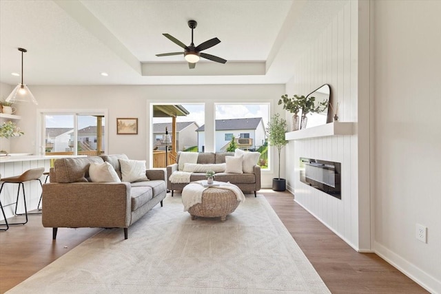 1902 16th Cir SE, Altoona, IA 50009 - living area featuring ceiling fan, wood finished floors, a raised ceiling, a large fireplace, and recessed lighting