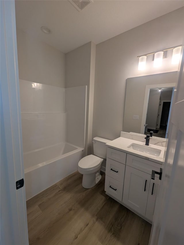 full bathroom featuring vanity, hardwood / wood-style floors, bathtub / shower combination, and toilet