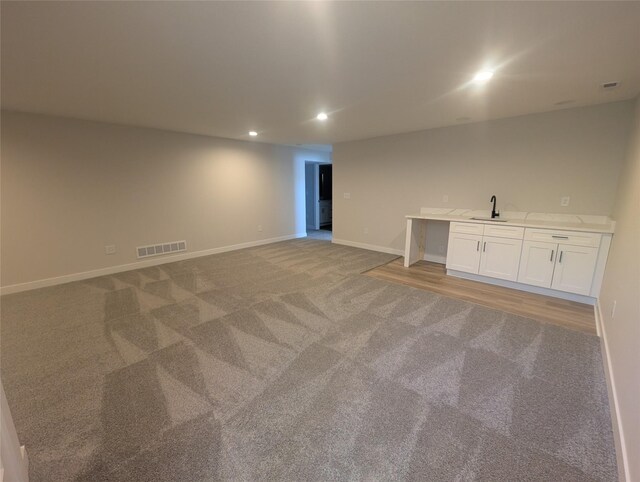 carpeted spare room featuring indoor wet bar