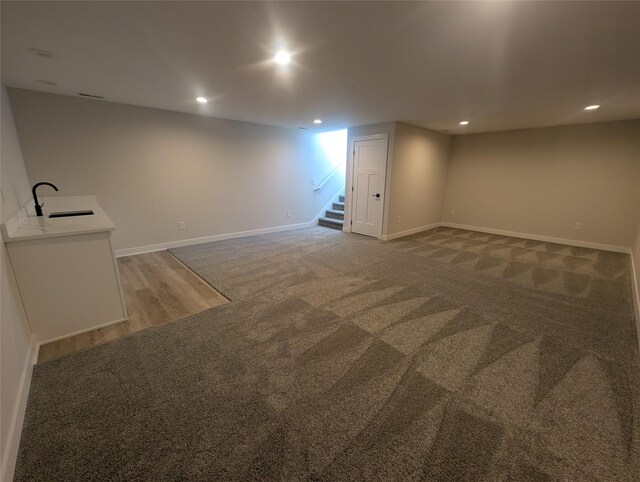 basement featuring carpet floors and sink