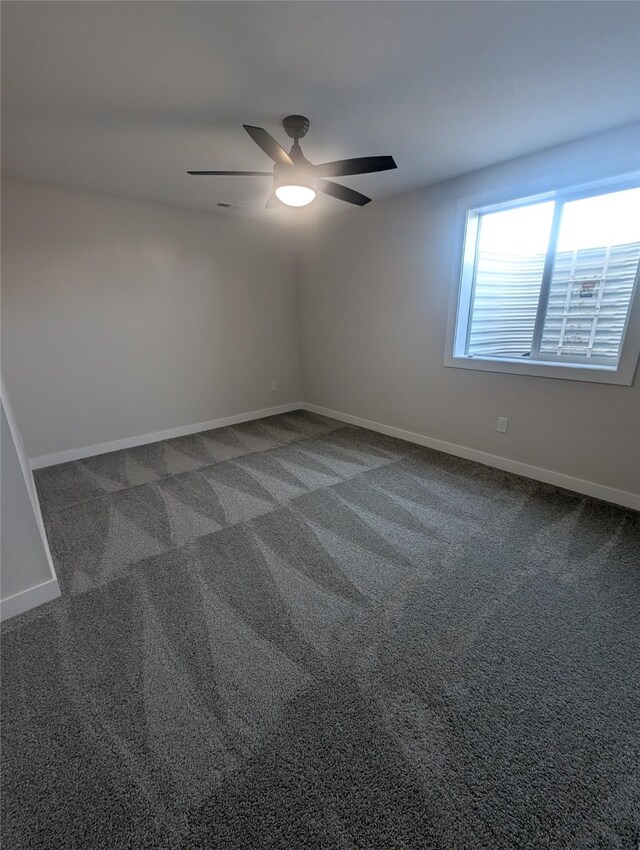 carpeted spare room featuring ceiling fan