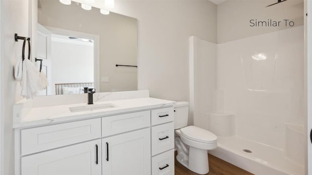 bathroom with walk in shower, wood-type flooring, vanity, and toilet