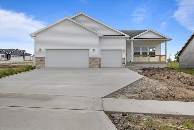 1632 20th Ave SE, Altoona, IA 50009 - view of front of property featuring an attached garage, covered porch, concrete driveway, and stone siding