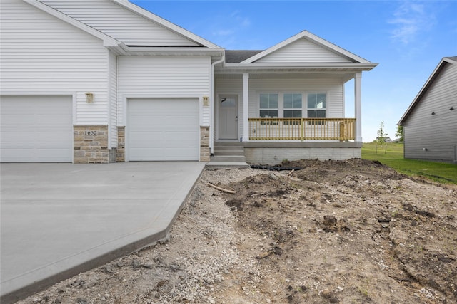 1632 20th Ave SE, Altoona, IA 50009 - view of front of property featuring covered porch, concrete driveway, a shingled roof, and stone siding
