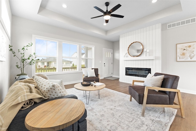 1632 20th Ave SE, Altoona, IA 50009 - living area featuring a raised ceiling, wood finished floors, ceiling fan, a fireplace, and baseboards