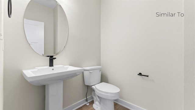 bathroom with hardwood / wood-style flooring and toilet