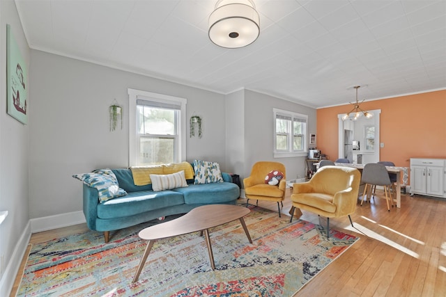 living room with ornamental molding, light hardwood / wood-style floors, and a healthy amount of sunlight