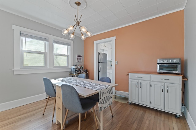 dining room featuring an inviting chandelier, crown molding, and light wood-type flooring