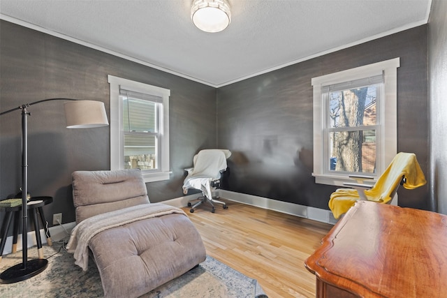 living area featuring crown molding, hardwood / wood-style floors, and a textured ceiling