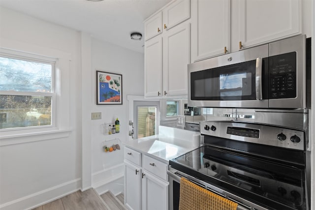 kitchen featuring white cabinetry, appliances with stainless steel finishes, and light wood-type flooring