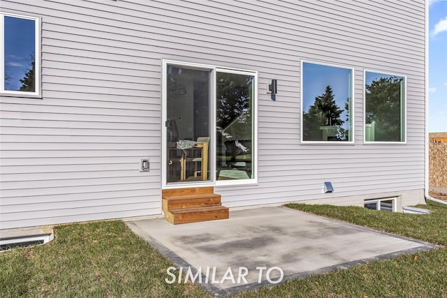 property entrance with a patio and a yard