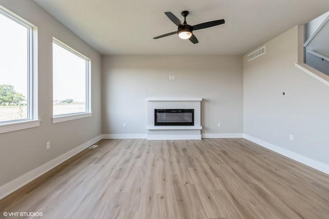 319 41st St SW, Altoona, IA 50009 - unfurnished living room with a glass covered fireplace, light wood-style floors, and a ceiling fan