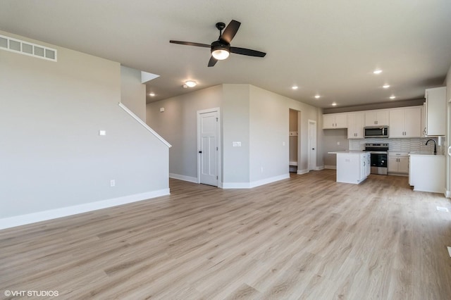 319 41st St SW, Altoona, IA 50009 - unfurnished living room featuring ceiling fan, recessed lighting, and light wood finished floors