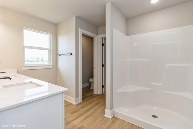 319 41st St SW, Altoona, IA 50009 - full bathroom with wood finished floors, double vanity, and a shower