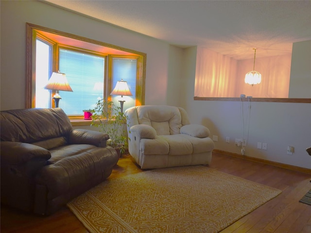 living room with an inviting chandelier, hardwood / wood-style floors, and a wealth of natural light