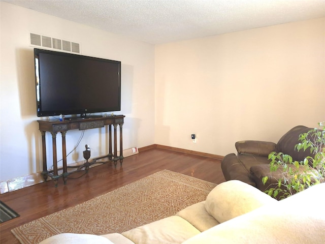 living room with dark hardwood / wood-style floors and a textured ceiling