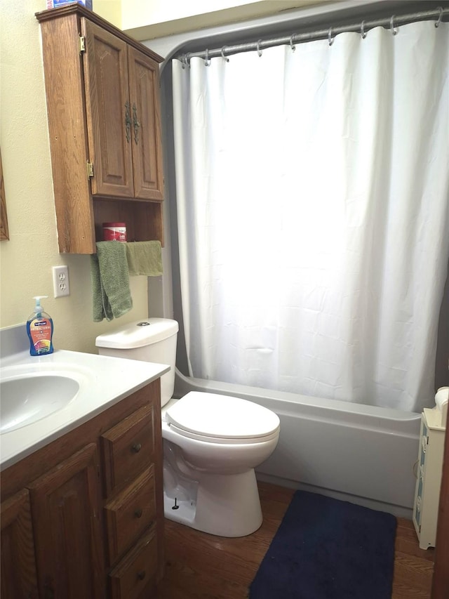 full bathroom with hardwood / wood-style flooring, vanity, shower / bath combo with shower curtain, and toilet