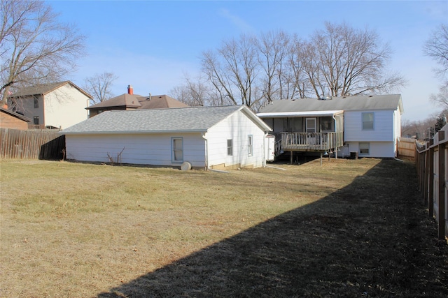 rear view of property featuring a sunroom and a lawn