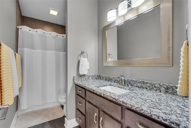 bathroom with vanity, wood-type flooring, and toilet