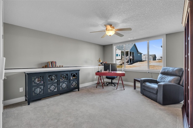 sitting room featuring ceiling fan, carpet flooring, and a textured ceiling