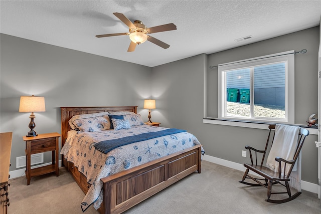 carpeted bedroom with ceiling fan and a textured ceiling