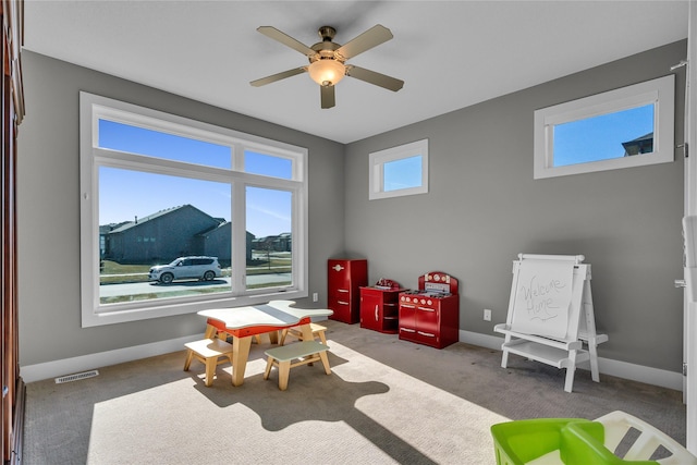 game room featuring light colored carpet and ceiling fan