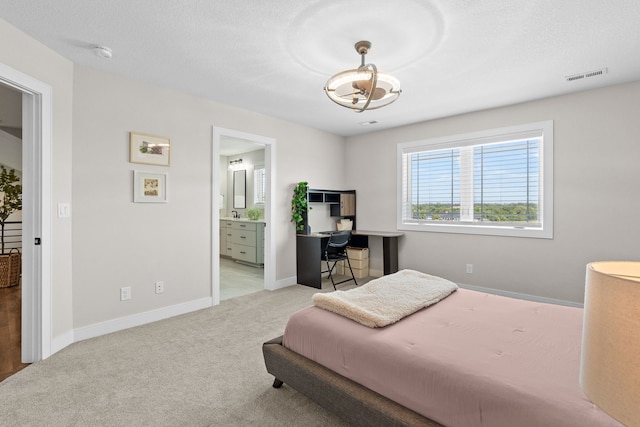 carpeted bedroom with baseboards, visible vents, and connected bathroom