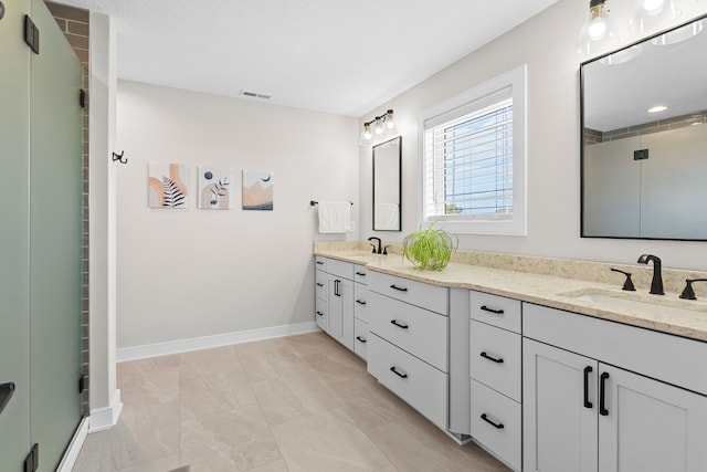 full bath featuring visible vents, a sink, a shower with door, and double vanity