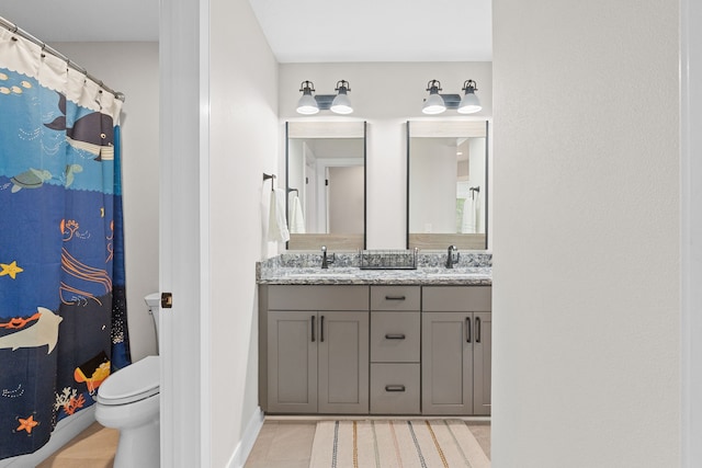 114 Tradition Dr, Polk City, IA 50226 - bathroom featuring double vanity, toilet, baseboards, and tile patterned flooring