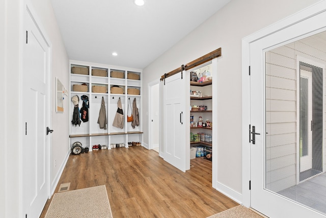 mudroom featuring a barn door, recessed lighting, visible vents, baseboards, and light wood-style floors