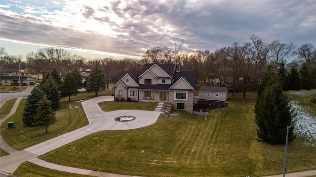 view of front of house featuring a front yard, stone siding, and curved driveway