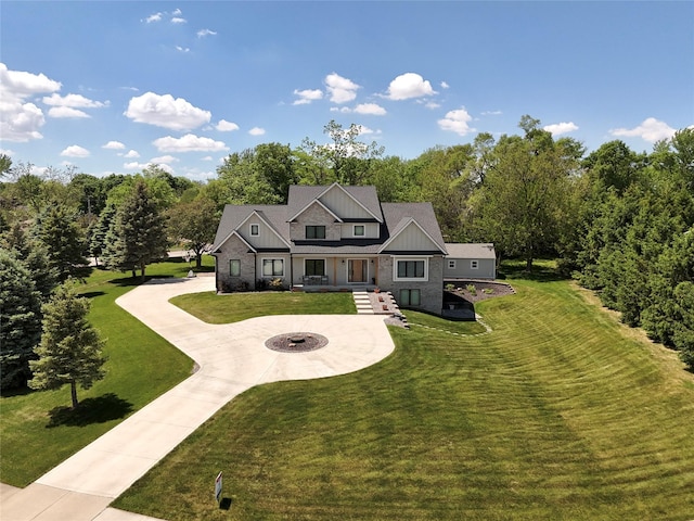 114 Tradition Dr, Polk City, IA 50226 - view of front facade with curved driveway, a front lawn, a fire pit, and board and batten siding