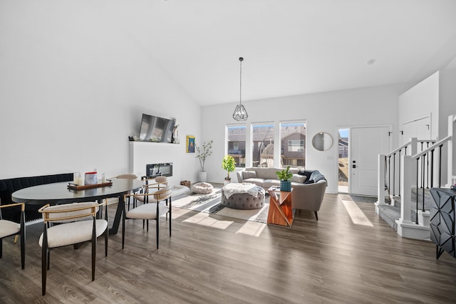 living room featuring stairs, wood finished floors, and high vaulted ceiling