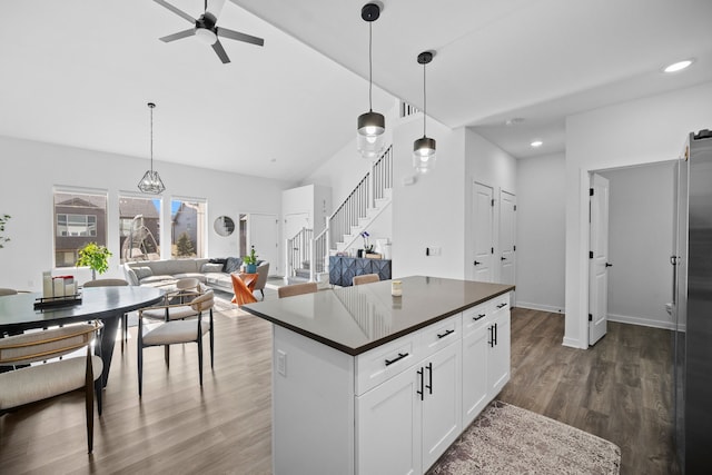 kitchen with white cabinetry, dark countertops, dark wood-style flooring, and hanging light fixtures