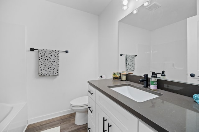 bathroom featuring visible vents, toilet, wood finished floors, baseboards, and vanity