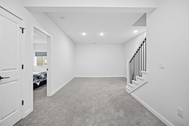 empty room featuring carpet flooring, recessed lighting, stairway, and baseboards