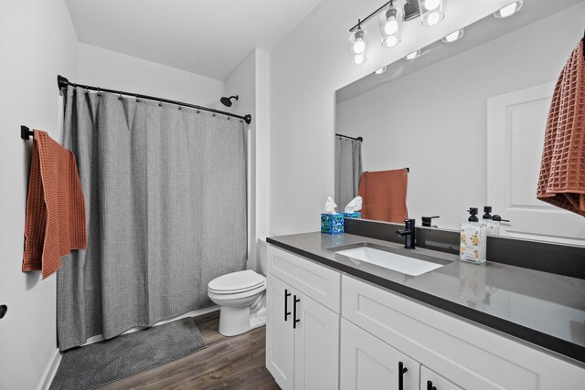 bathroom featuring vanity, wood-type flooring, and toilet